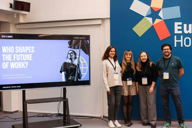 A group portrait beside the Stay & Shape conference display